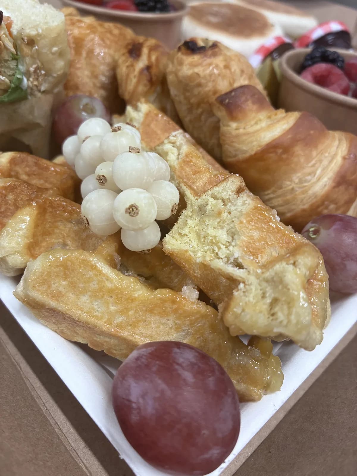 Gros plan sur les viennoiseries, gaufres et fruits frais de la Brunch Box