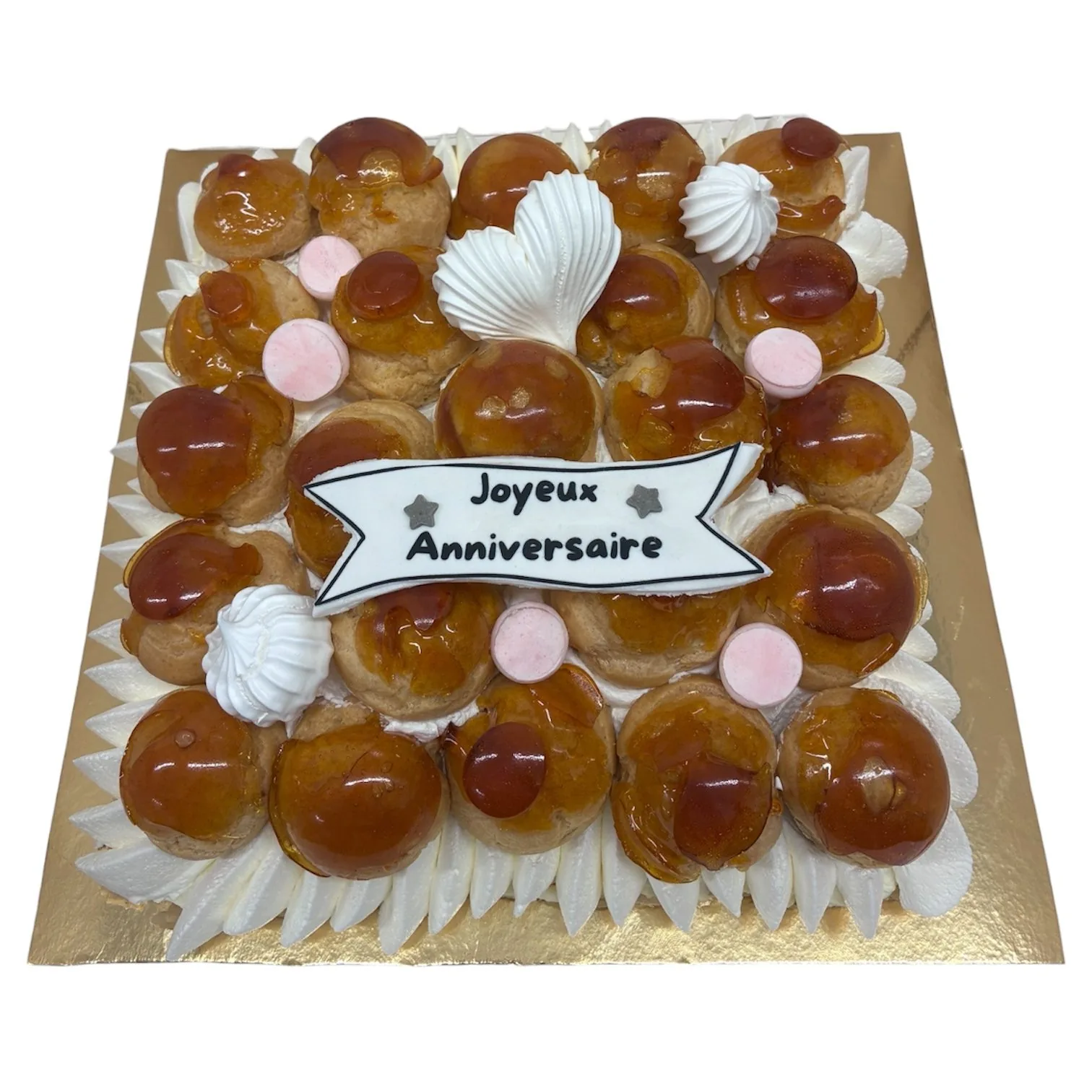 Pièce montée carrée composée de choux caramélisés sur socle de chantilly, bannière « Joyeux Anniversaire »